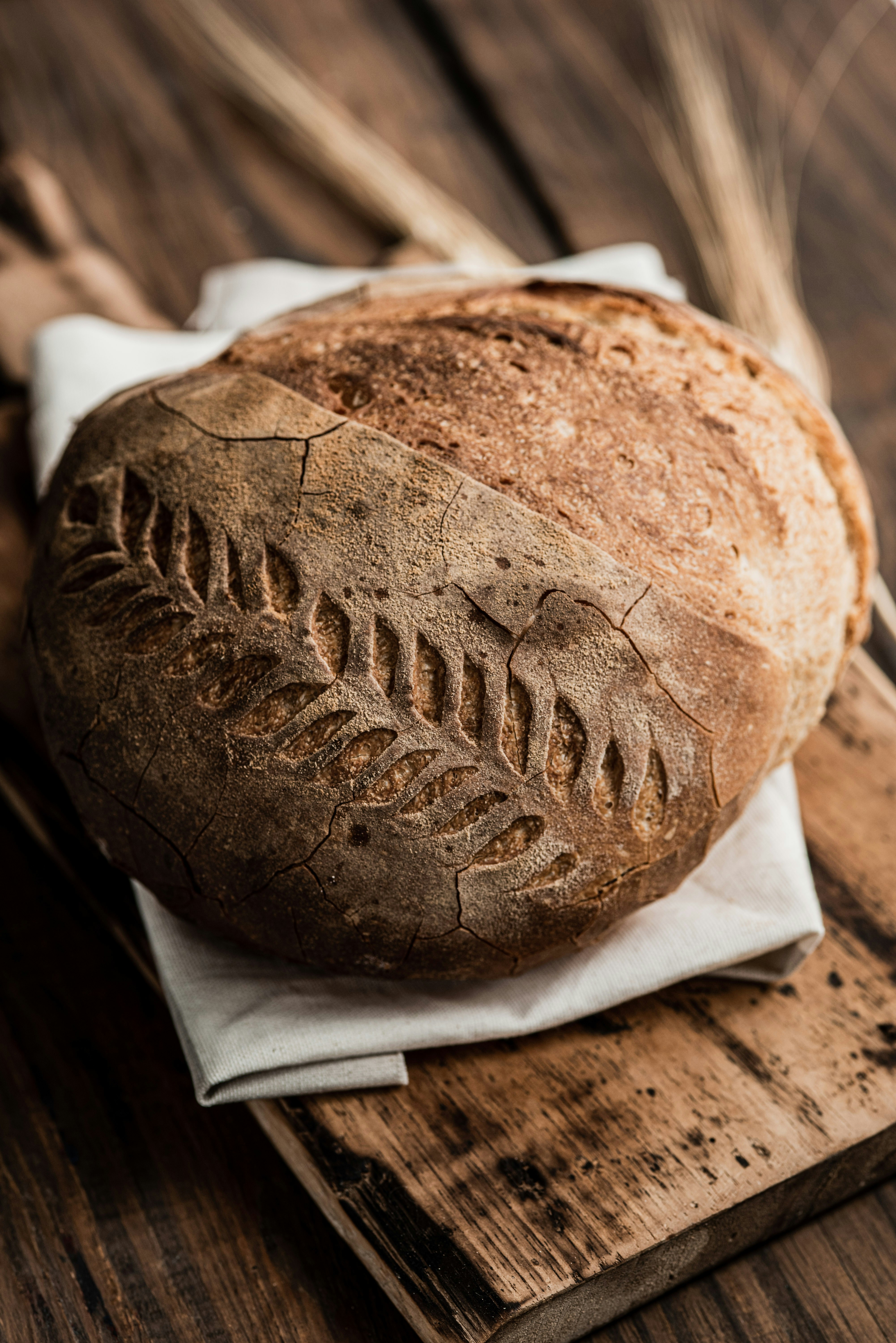 Round artisan sourdough loaf on linen and a wood board