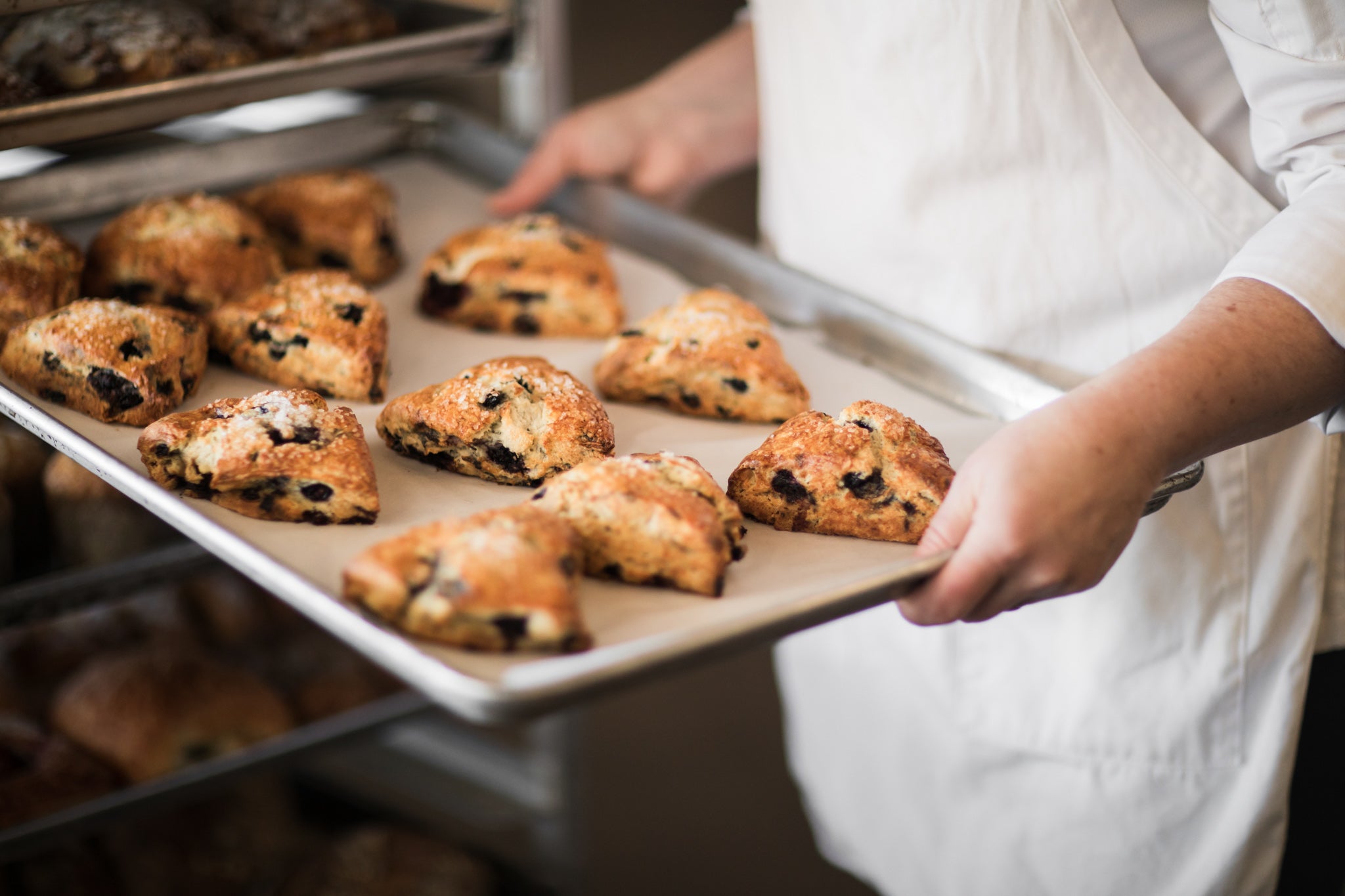 Baker carrying a tray of fresh pastries