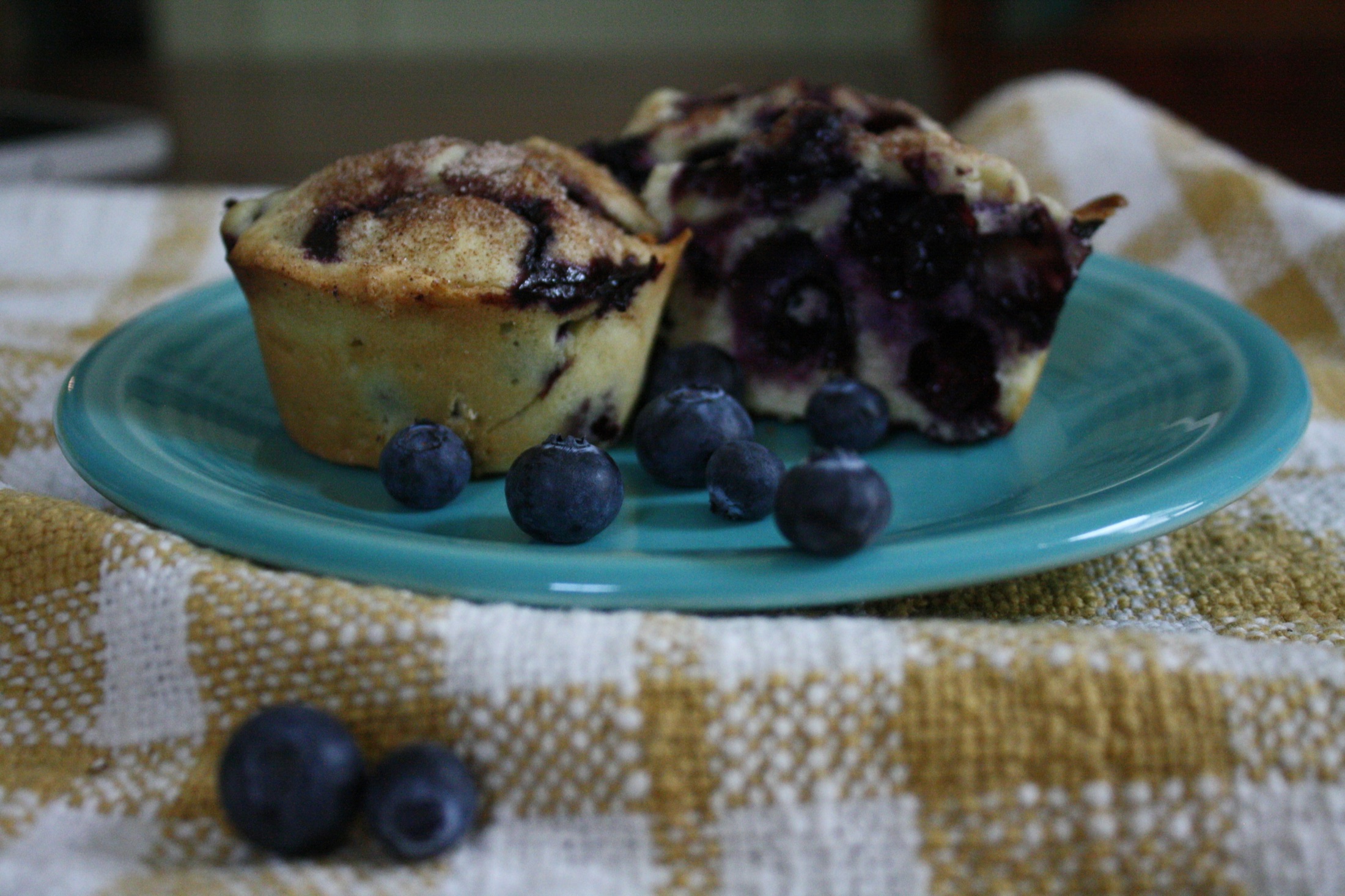 Blueberry muffins on a blue plate with fresh berries